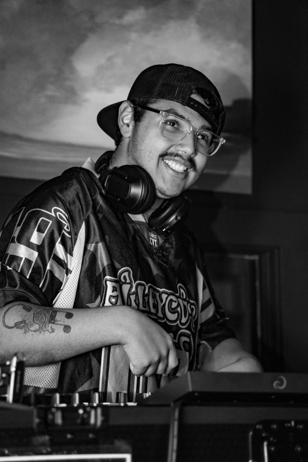 Black and white portrait of Dill the Menace grinning behind the decks