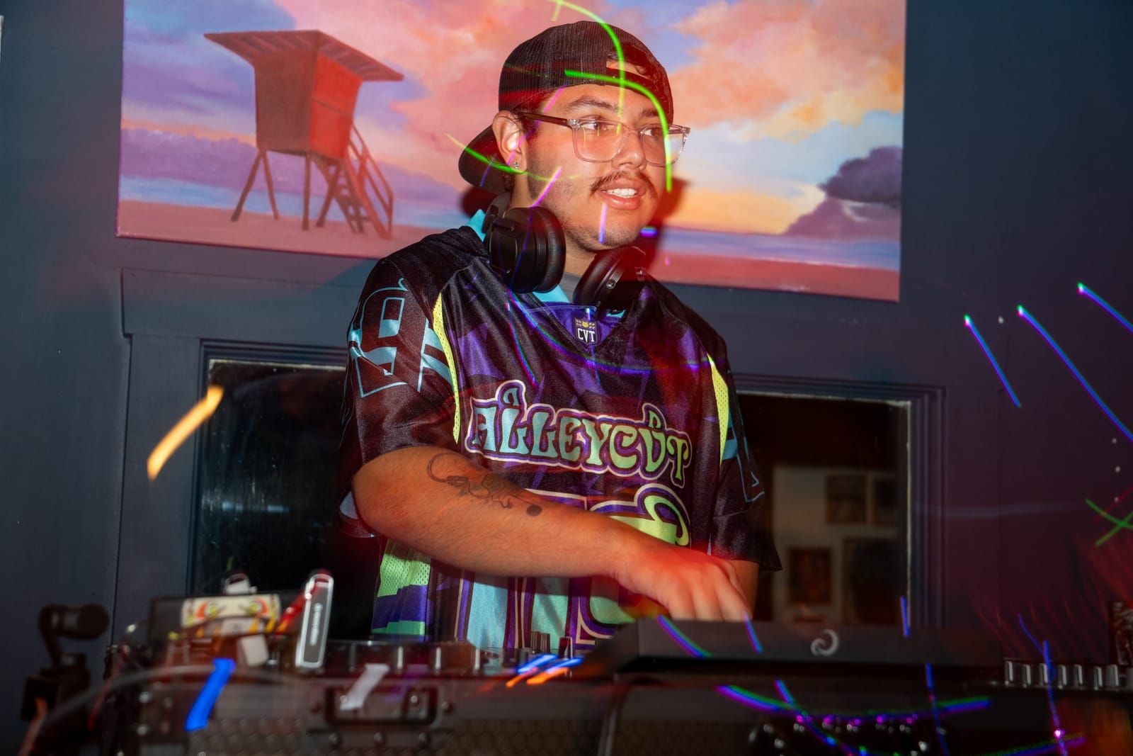 Colored light trails around Dill the Menace as he works the decks