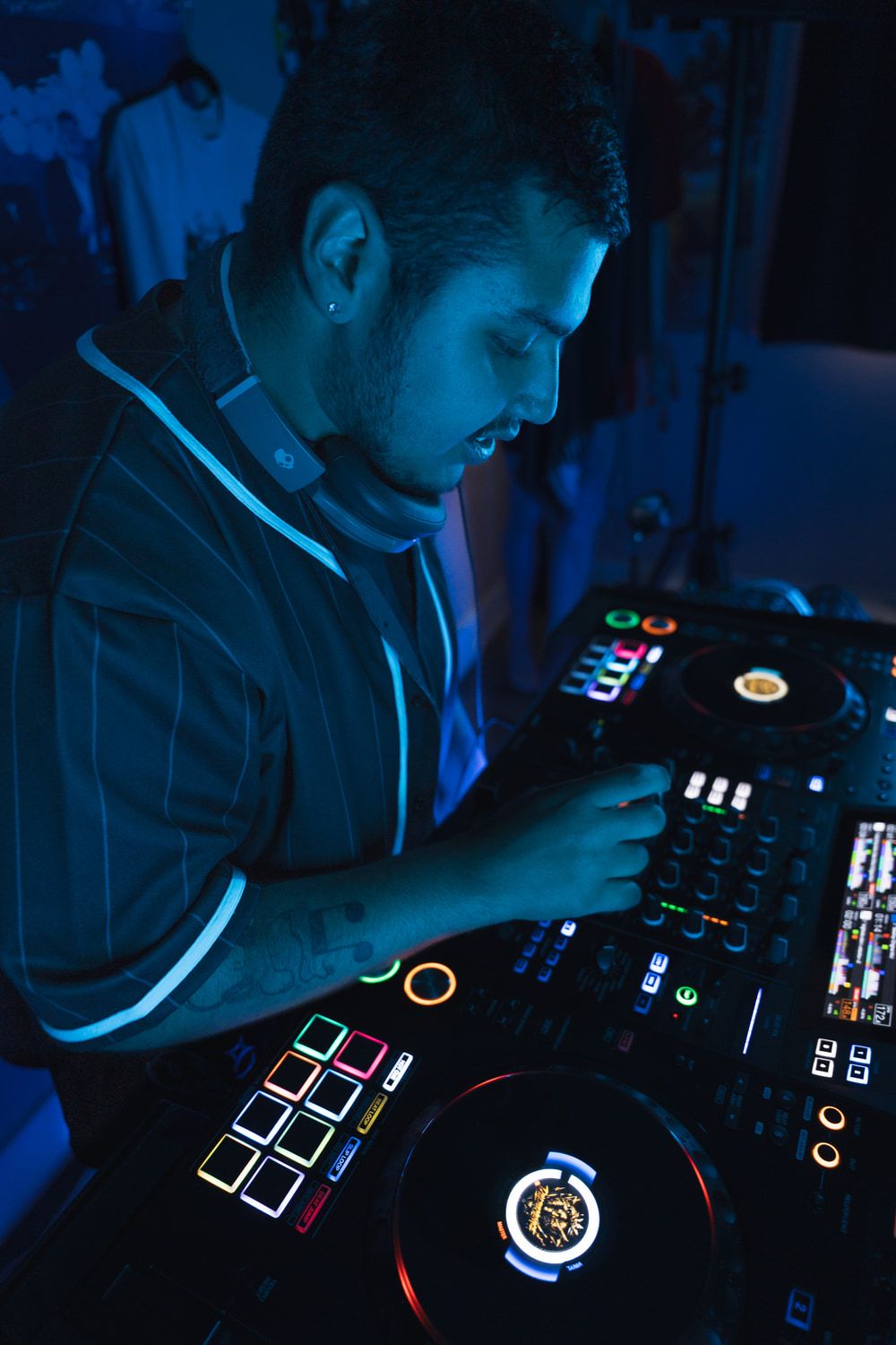 Dill the Menace mixing during a blue-lit DJ session