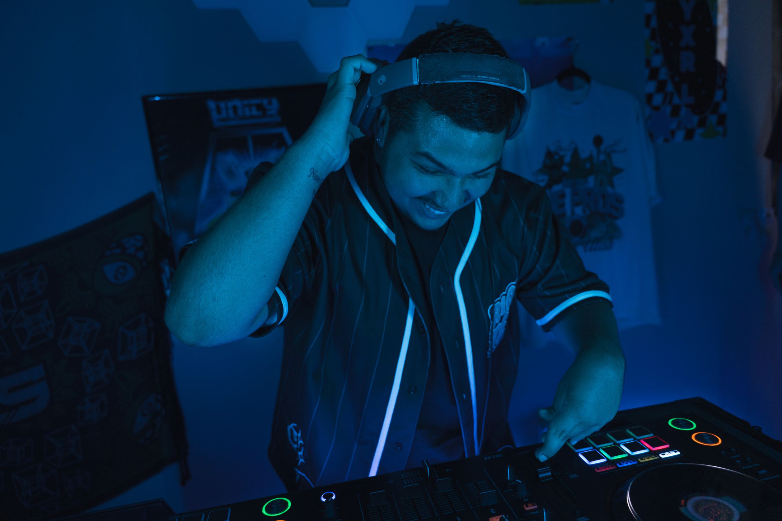Dill the Menace DJing behind the decks with blue stage lighting